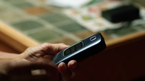 A mature woman dialing 911 on a flip phone Stock Footage 114247916