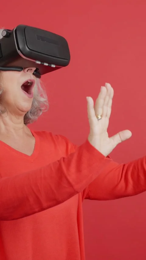 Mature woman gesturing while using a virtual reality goggles Stock Footage 239908948