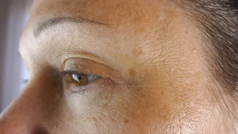 Mature woman gives herself wrinkle cream to eye Stock Footage