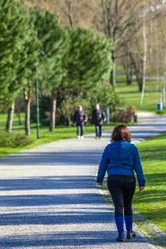 Mature woman going for a fitness walk in Parque da Devesa Urban Park. Stock Photos