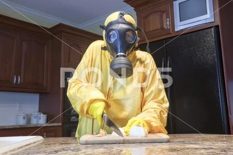 Mature woman in Haz Mat suit chopping onions Stock Photos