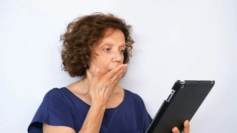 Mature woman in shock while using tablet Isolated on white background. Stock Footage 114396536