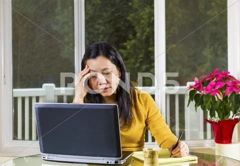 Mature woman stressed while working at home Stock Photos