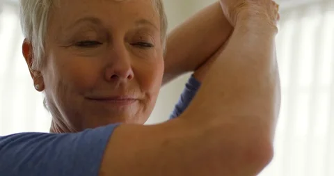 Mature woman stretching while practicing yoga. 스톡 동영상 88370970