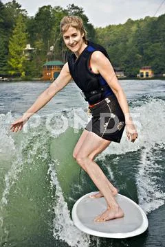 Mature woman on a surfboard Stock Photos
