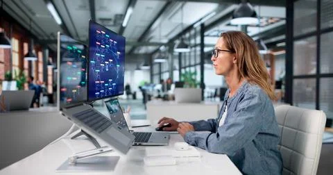 Mature Woman Uses Low Code Laptop Software To Build Workflow Automation. Fotos Stock