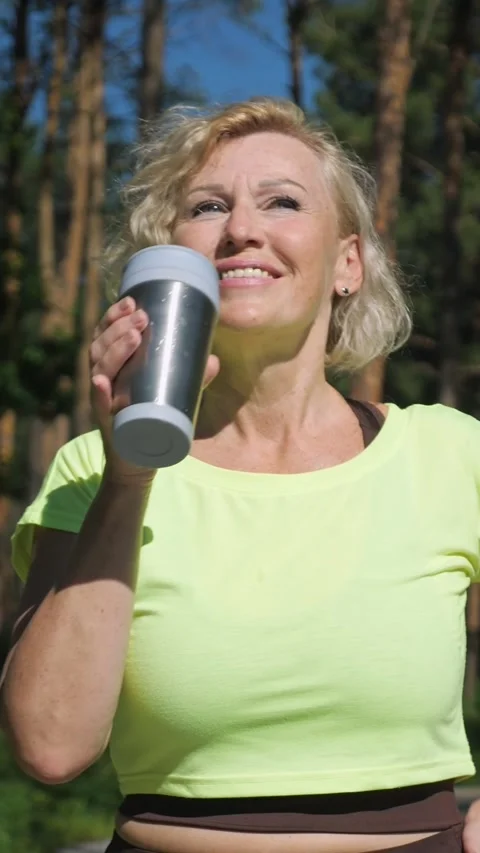 Mature woman using smartwatch during workout break Video stock 341442004