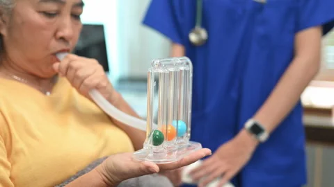 Mature woman using a spirometer to help patients to improve the functioning of Video stock 287613982