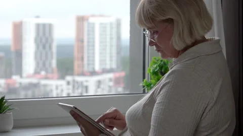 Mature woman using tablet by window Stock-Footage 294097894