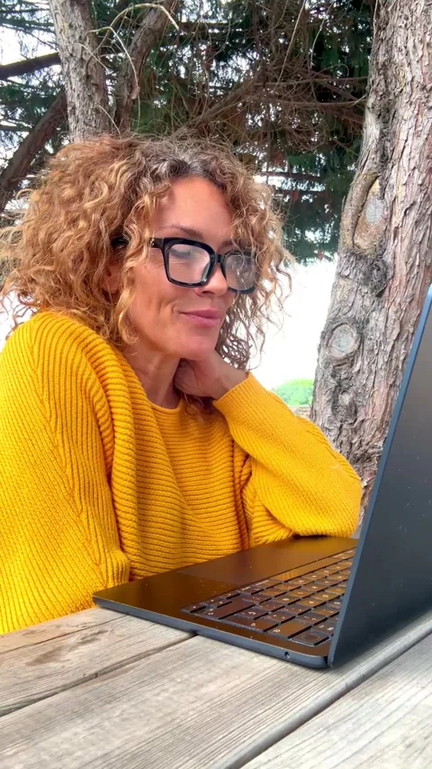 Mature woman working remotely on laptop outdoors Stock Footage 344856428