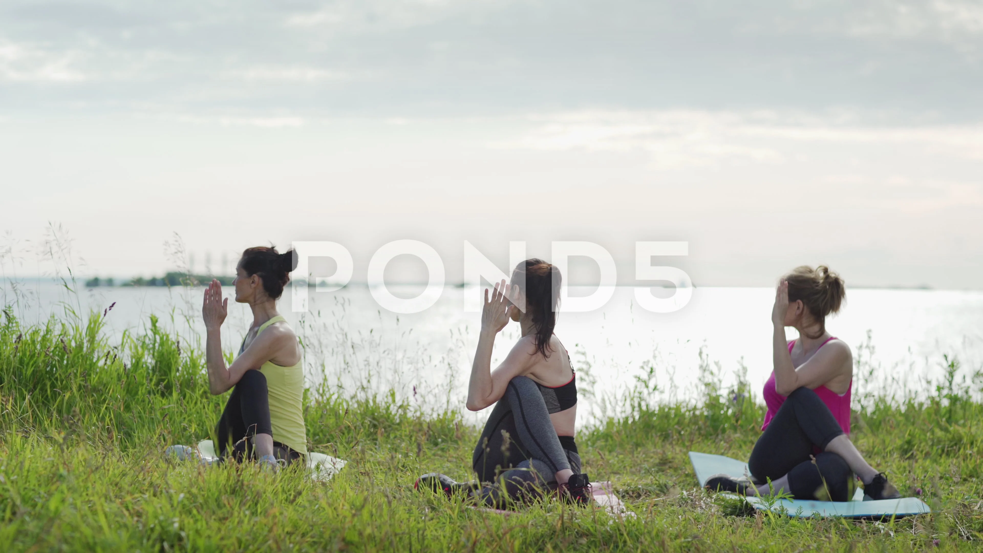 Mature women doing yoga twist in nature