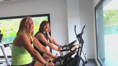 Mature women looking at camera while pedaling on spin bikes during cardio w.. Stock Footage 285092408