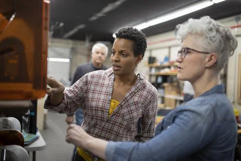 Mature women using 3d printer in workshop Foto stock