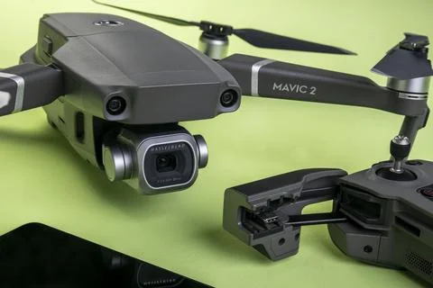 Mavic 2 pro drone, its controller and a cell phone on green background Stock Photos