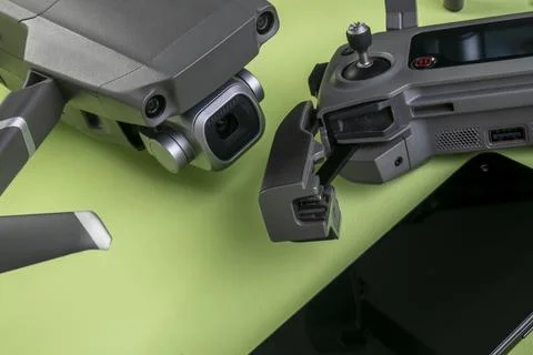Mavic 2 pro drone, its controller and a smartphone on green background Stock Photos