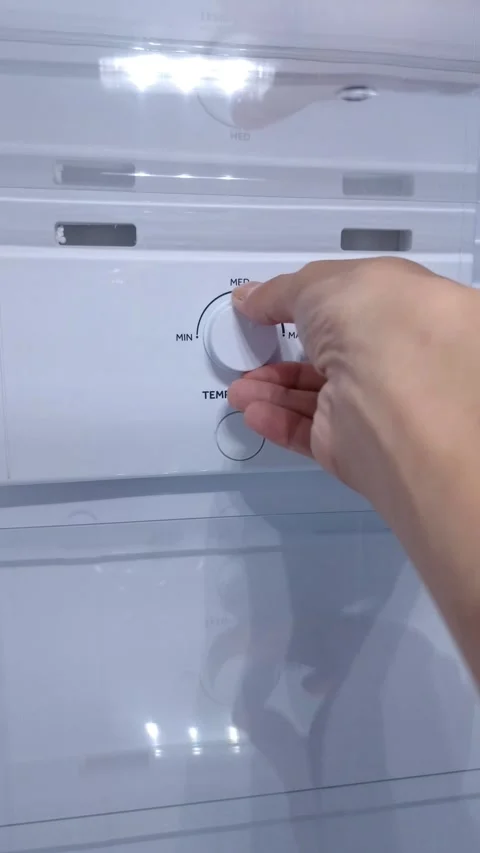 Max to Min. Hand adjusts refrigerator temperature dial Stock Footage 332259847