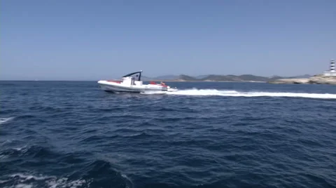 Maxi rib navigating fast in front of a lighthouse  Stock Footage 43317636