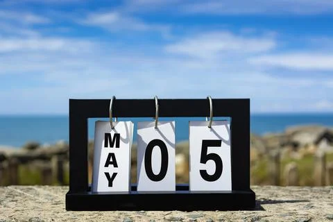 May 05 calendar date text on wooden frame with blurred background of ocean. Stock Photos