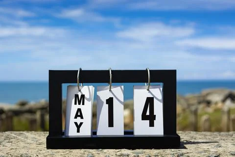 May 14 calendar date text on wooden frame with blurred background of ocean. Stock Photos