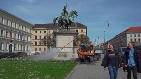May 15, 2022. Munich, Germany. orangefarbenes Servicefahrzeug sprueht Wasser auf Stock Footage 335247419