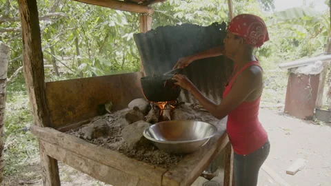 May 25, 2024: Hato Mayor, Dominican Republic, woman cooking over open fire in Stock Footage 310775344
