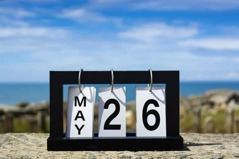 May 26 calendar date text on wooden frame with blurred background of ocean. Stock Photos