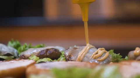 Mayonnaise on delicious cheese burger in slow motion Stock Footage