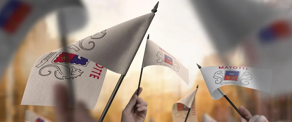 Mayotte flags in their hands on a blurred urban background Stock Photos