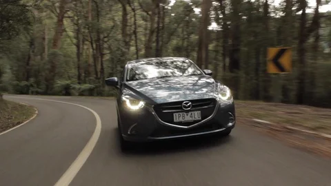 Mazda 2 Driving Through Scenic Forest 2 Stock Footage