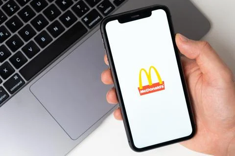 McDonalds the application is open in the smartphone. The man is holding a mobile Foto stock