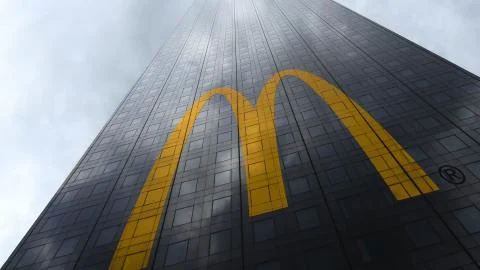 McDonald's logo on a skyscraper facade reflecting clouds. Editorial 3D rendering Stock Illustration
