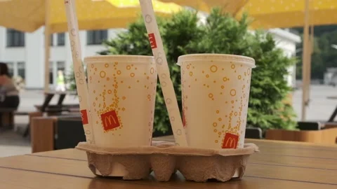 McDonald's refreshing soft drink with a straw in a cardboard cupholder Stock Footage 297777999