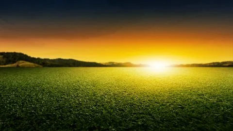 Meadow fields with mountain range and beautiful sunset scene view Stock Photos