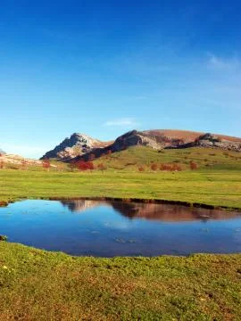 Meadow of gorbea mountain and reflections on a lake Stock Photos
