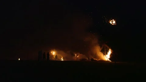 Meadow at midsummer night, various bonfires are burning, people silhouettes Stock Footage 253410238
