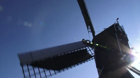 Meadow mill - low angle backside - wicks turning against blue sky - backlight Stock Footage 73278967