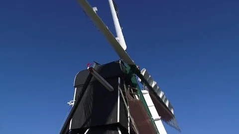 Meadow mill - low angle - wicks turning against blue sky Stock Footage 73279293