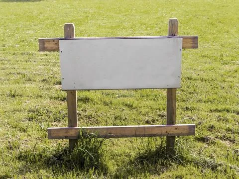 On a meadow is a sign for a building plot for a house for sale. Building site 写真素材