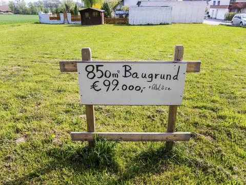 On a meadow is a sign for a building plot for a house for sale. Building site 写真素材