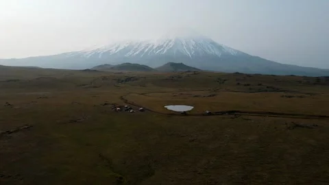 Meadows overlooking a snowy volcano 库存影片 168151704