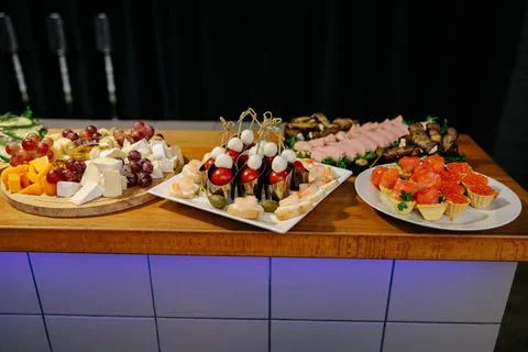 Meal. Festive buffet table for guests. Assortment of cold cuts,canapes on wooden Stock Photos