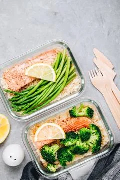Meal prep lunch box containers with baked salmon fish, rice, green broccoli a Foto stock