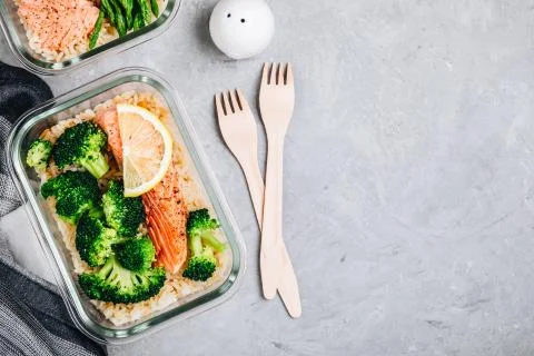 Meal prep lunch box containers with baked salmon fish, rice, green broccoli Stock Photos
