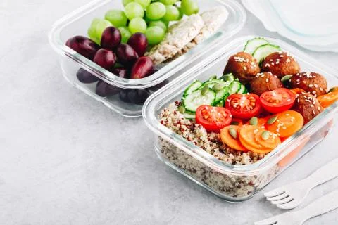 Meal prep lunch box containers with quinoa, meatballs cucumbers, carrots and  Stock Photos