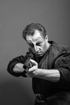 Mean guy looking down and holding gun Stock Photos