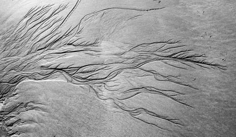 Meandering pattern of run off water in sand beach Porpoise Bay Catlins Stock Photos