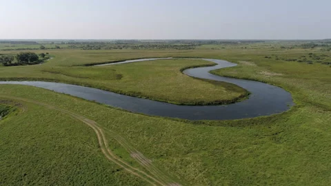 The meandering river flows through the field 스톡 동영상 93028143