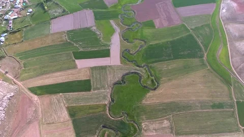 Meandering river winds through patchwork farmland - River Valley and Cultivated Stock Footage 339574845