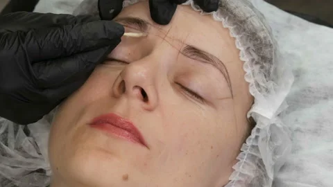 Measure the shape of new eyebrows with special dyed thread. Microblading Stock Footage 162904096