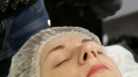 Measure the shape of new eyebrows with special dyed thread. Microblading Stock Footage 162908128